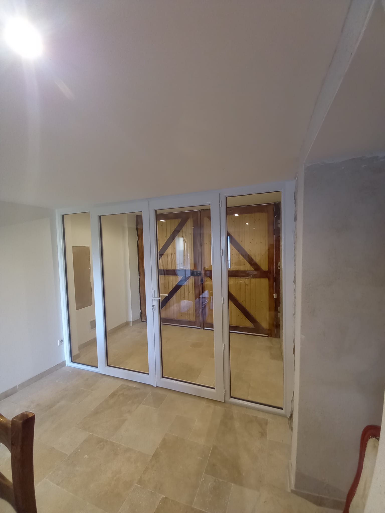 Création d'un sas par porte fenêtre avec deux parties fixes de chaque côté en pvc blanc.